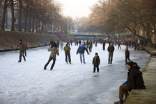 900012 Afbeelding van schaatsers op de bevroren Stadsbuitengracht te Utrecht, met op de achtergrond de Bartholomeïbrug.